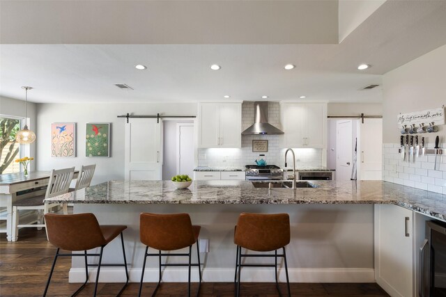 4018 Crown Shore Dr, Dallas, TX 75244 - kitchen with a barn door, wall chimney exhaust hood, a sink, wine cooler, and recessed lighting