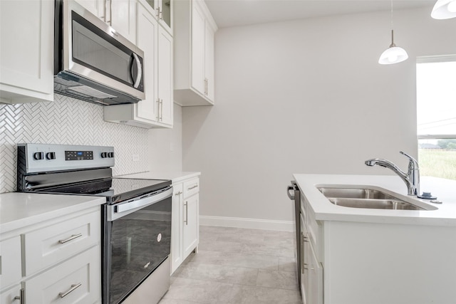 500 Melody Cir, Kaufman, TX 75142 - kitchen featuring appliances with stainless steel finishes, a sink, tasteful backsplash, white cabinetry, and decorative light fixtures