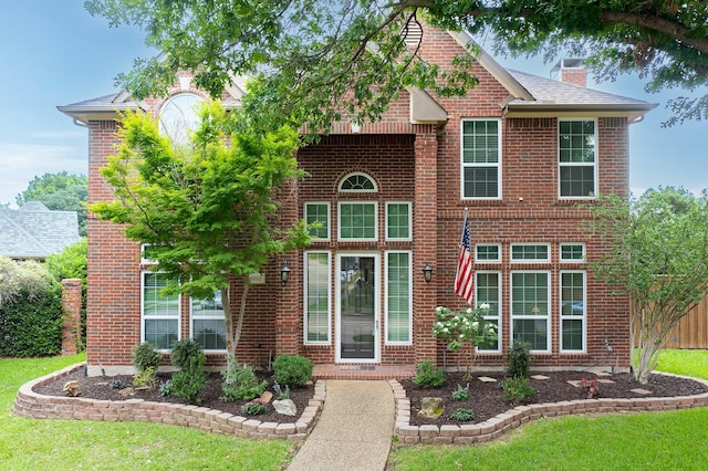 6916 Arvida Dr, Plano, TX 75023 - traditional-style home featuring brick siding, a chimney, and a front yard
