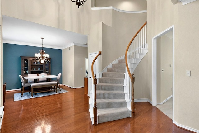 6916 Arvida Dr, Plano, TX 75023 - entryway with a chandelier, wood finished floors, stairs, baseboards, and crown molding