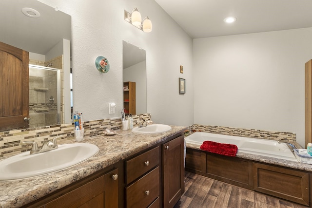 123 Little River Bnd, Mabank, TX 75156 - full bathroom with a shower stall, wood finished floors, a garden tub, double vanity, and backsplash