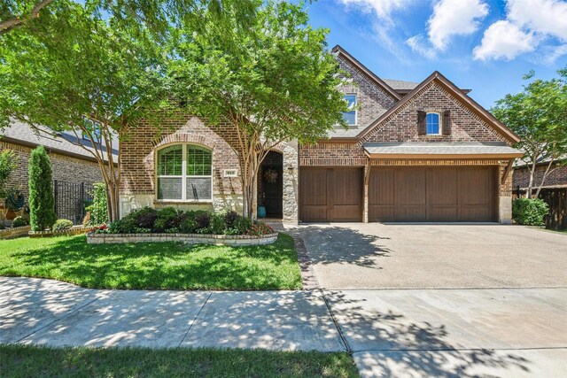 915 Prairie Ridge Ln, Arlington, TX 76005 - view of front facade with brick siding, concrete driveway, stone siding, and a garage