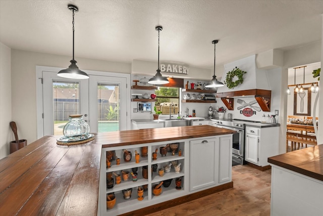 2302 Warwick Ave, Grand Prairie, TX 75052 - kitchen featuring butcher block countertops, open shelves, stainless steel electric stove, custom range hood, and white cabinetry