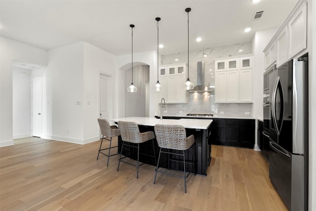 1812 Welker Dr, Van Alstyne, TX 75495 - kitchen with smart refrigerator, backsplash, light countertops, light wood-type flooring, and wall chimney exhaust hood