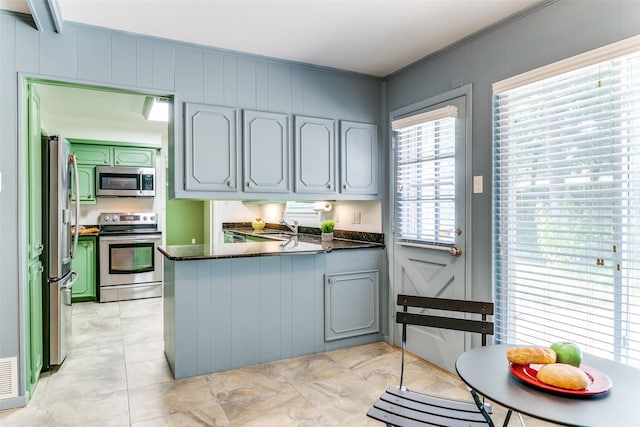 907 Glen Dell Dr, Irving, TX 75061 - kitchen with stainless steel appliances, a peninsula, dark countertops, crown molding, and a decorative wall
