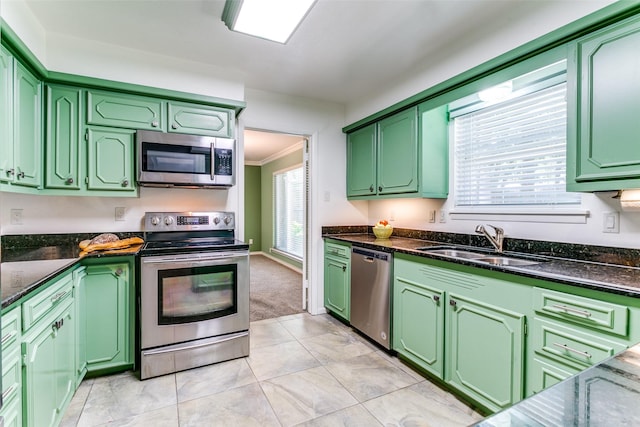 907 Glen Dell Dr, Irving, TX 75061 - kitchen featuring appliances with stainless steel finishes, green cabinetry, ornamental molding, dark stone countertops, and light tile patterned flooring
