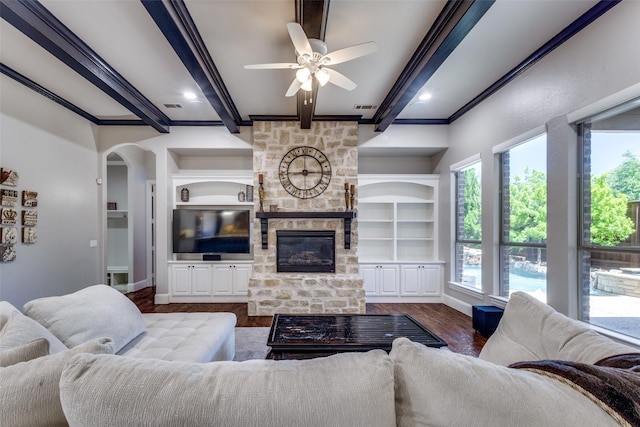 11626 Capitan Ln, Frisco, TX 75033 - living room featuring wood finished floors, beam ceiling, ceiling fan, a fireplace, and arched walkways