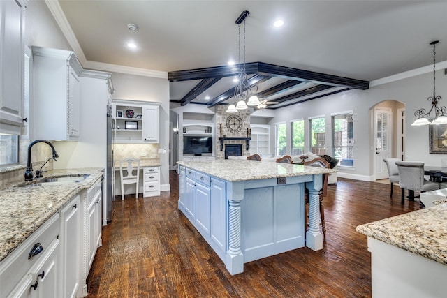 11626 Capitan Ln, Frisco, TX 75033 - kitchen featuring a sink, a chandelier, open floor plan, arched walkways, and ornamental molding