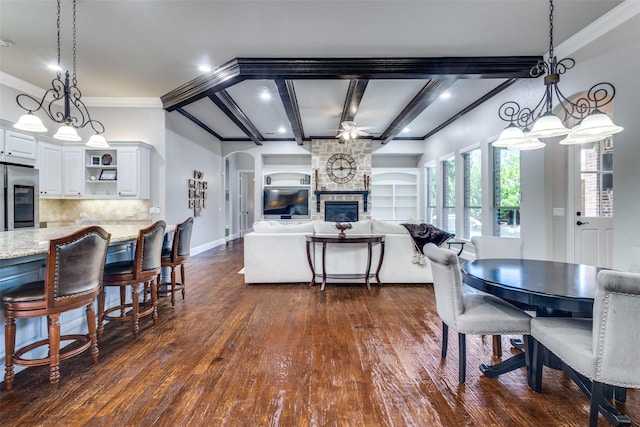 11626 Capitan Ln, Frisco, TX 75033 - dining space featuring dark wood-style flooring, beam ceiling, a fireplace, crown molding, and baseboards