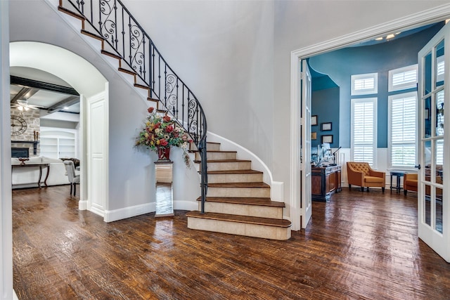 11626 Capitan Ln, Frisco, TX 75033 - foyer with a towering ceiling, ceiling fan, wood finished floors, stairs, and arched walkways