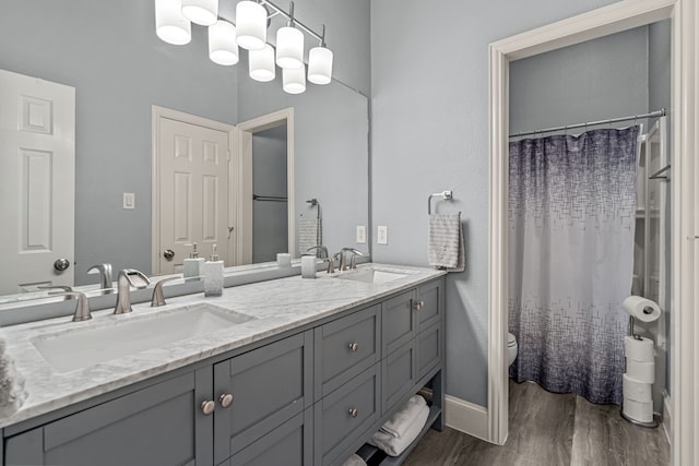 2433 Mallard Dr, Little Elm, TX 75068 - bathroom with wood finished floors, double vanity, toilet, baseboards, and a shower with curtain