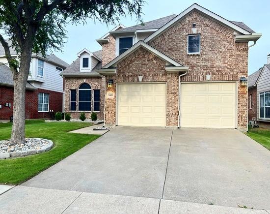 2433 Mallard Dr, Little Elm, TX 75068 - traditional home featuring driveway, a front lawn, brick siding, and an attached garage