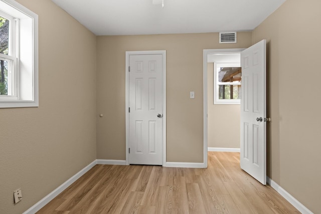 310 Reynolds, Pittsburg, TX 75686 - unfurnished bedroom featuring light wood-style floors, multiple windows, and baseboards