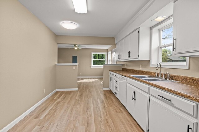 310 Reynolds, Pittsburg, TX 75686 - kitchen with a sink, light wood finished floors, dark countertops, white cabinetry, and a ceiling fan