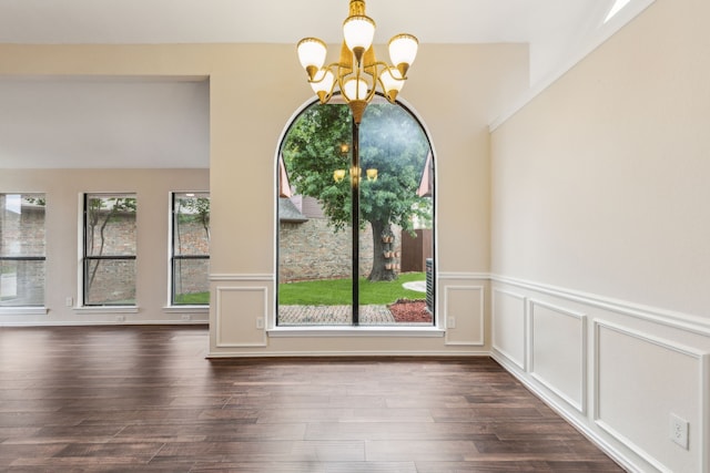 4103 Bendwood Ln, Dallas, TX 75287 - unfurnished dining area featuring a chandelier, dark wood-type flooring, wainscoting, and a decorative wall