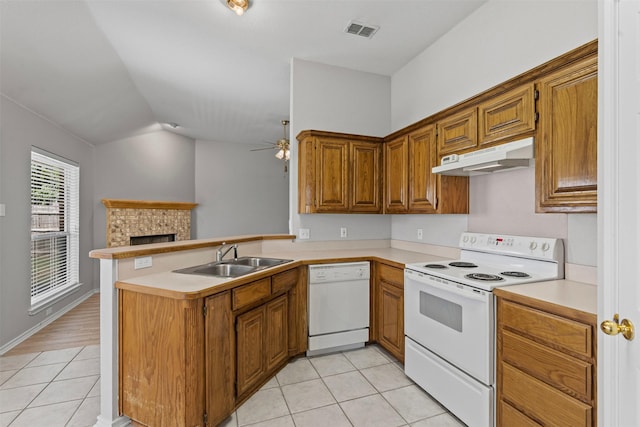 1039 Spring Hill Dr, Saginaw, TX 76179 - kitchen with white appliances, under cabinet range hood, light tile patterned floors, a peninsula, and vaulted ceiling