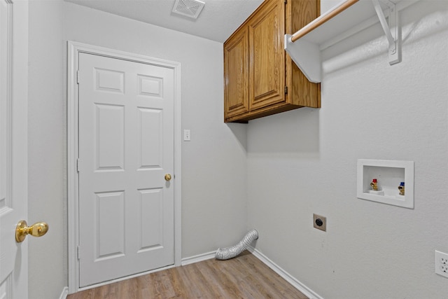 1039 Spring Hill Dr, Saginaw, TX 76179 - laundry area featuring hookup for an electric dryer, cabinet space, light wood-style floors, and washer hookup