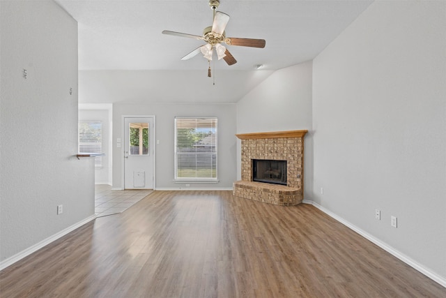 1039 Spring Hill Dr, Saginaw, TX 76179 - unfurnished living room featuring lofted ceiling, a brick fireplace, a ceiling fan, and wood finished floors