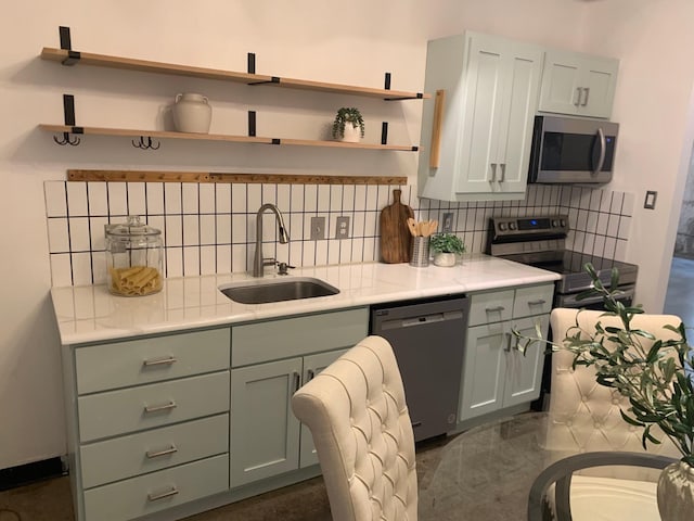1122 Jackson St Unit 416, Dallas, TX 75202 - kitchen featuring stainless steel appliances, a sink, open shelves, and backsplash