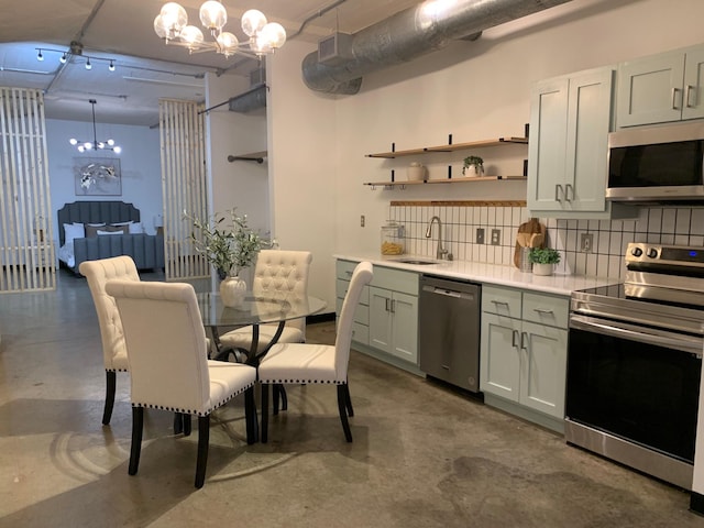 1122 Jackson St Unit 416, Dallas, TX 75202 - kitchen with appliances with stainless steel finishes, a sink, finished concrete flooring, and a chandelier