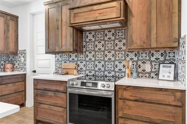 416 Redbud Ln, Tolar, TX 76476 - kitchen featuring electric stove, decorative backsplash, custom range hood, light countertops, and light wood-style flooring