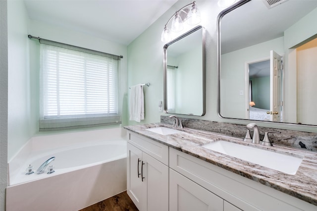 9912 Fillmore Dr, Mckinney, TX 75072 - full bath with a garden tub, double vanity, and wood finished floors