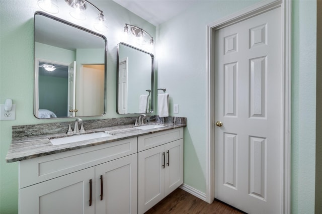 9912 Fillmore Dr, Mckinney, TX 75072 - bathroom featuring wood finished floors, double vanity, and baseboards