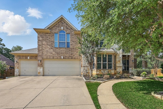 2410 Honey Dr, Arlington, TX 76001 - traditional home with concrete driveway, brick siding, stone siding, and a garage