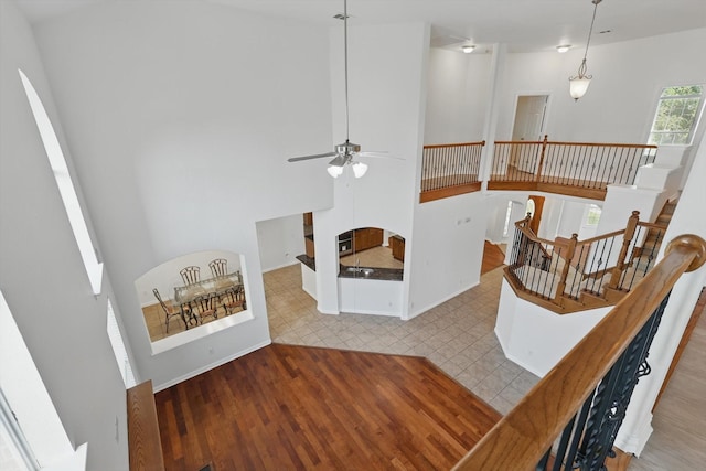 2410 Honey Dr, Arlington, TX 76001 - stairs with ceiling fan, wood finished floors, and a high ceiling