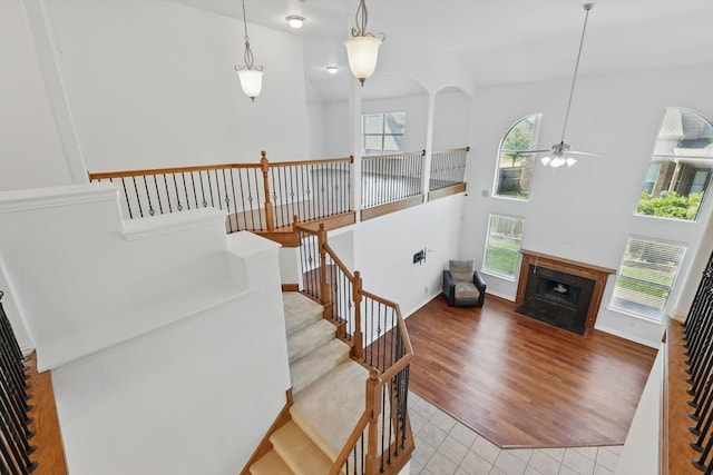 2410 Honey Dr, Arlington, TX 76001 - staircase featuring ceiling fan, tile patterned flooring, and a fireplace with flush hearth