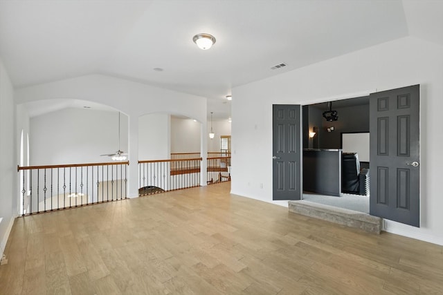 2410 Honey Dr, Arlington, TX 76001 - unfurnished room featuring a ceiling fan, light wood-type flooring, vaulted ceiling, and arched walkways