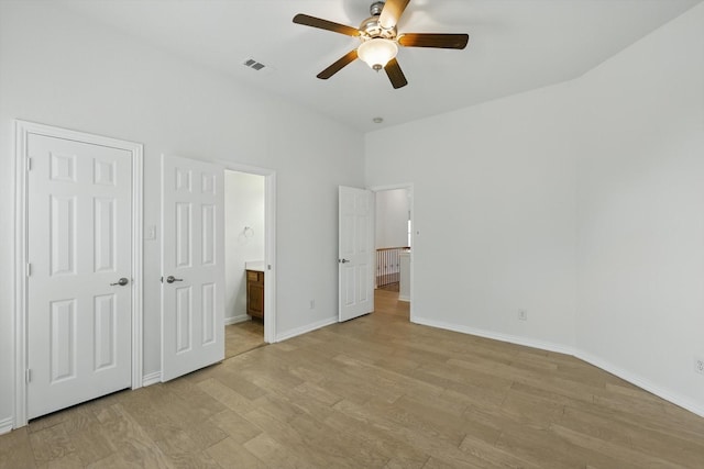 2410 Honey Dr, Arlington, TX 76001 - unfurnished bedroom featuring light wood finished floors, connected bathroom, and ceiling fan