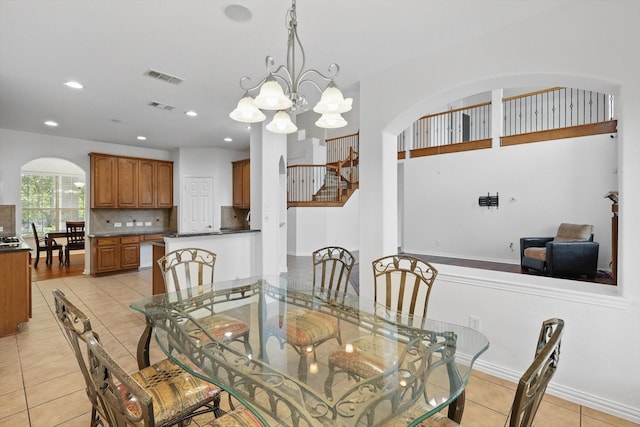 2410 Honey Dr, Arlington, TX 76001 - dining space featuring arched walkways, light tile patterned flooring, recessed lighting, and a chandelier