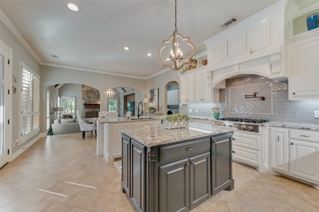 105 Orion Ct, Aurora, TX 76078 - kitchen featuring arched walkways, a chandelier, white cabinetry, a sink, and open floor plan