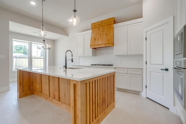 2602 23rd St, Fort Worth, TX 76106 - kitchen featuring a sink, decorative backsplash, stainless steel appliances, white cabinets, and premium range hood
