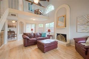 14151 Montfort Dr Unit 201, Dallas, TX 75254 - living area with ceiling fan, wood finished floors, arched walkways, a fireplace with raised hearth, and a high ceiling