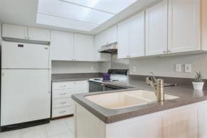 14151 Montfort Dr Unit 201, Dallas, TX 75254 - kitchen featuring freestanding refrigerator, range with electric cooktop, a peninsula, under cabinet range hood, and a sink