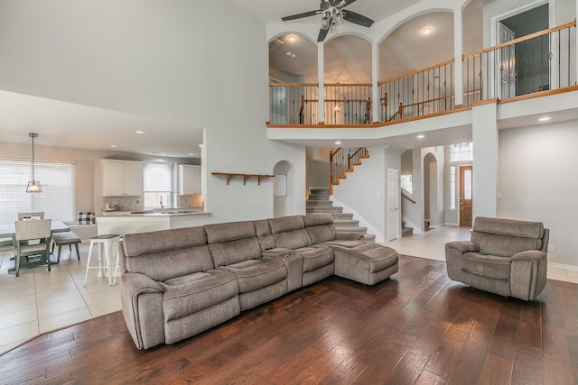 5424 Yellow Birch Dr, Fort Worth, TX 76244 - living area featuring arched walkways, wood-type flooring, stairway, a ceiling fan, and a towering ceiling