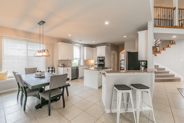 5424 Yellow Birch Dr, Fort Worth, TX 76244 - kitchen featuring appliances with stainless steel finishes, a sink, a kitchen island, light tile patterned floors, and recessed lighting