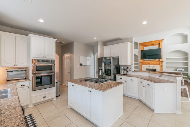 5424 Yellow Birch Dr, Fort Worth, TX 76244 - kitchen featuring appliances with stainless steel finishes, a center island, light stone countertops, light tile patterned floors, and recessed lighting