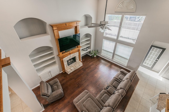 5424 Yellow Birch Dr, Fort Worth, TX 76244 - living area featuring a towering ceiling, ceiling fan, built in shelves, a stone fireplace, and baseboards