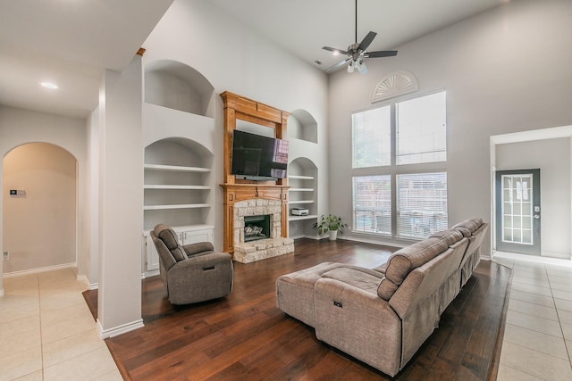 5424 Yellow Birch Dr, Fort Worth, TX 76244 - living room featuring a high ceiling, ceiling fan, built in features, arched walkways, and baseboards