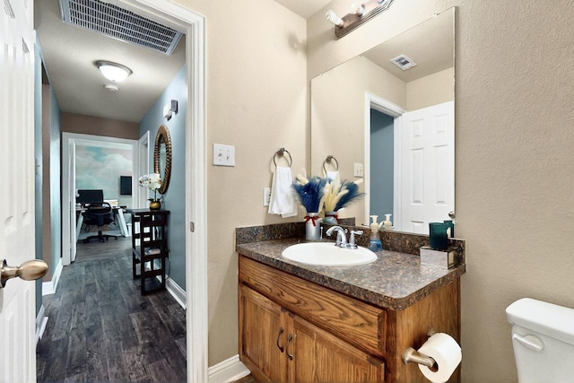2715 Myopia Ct, Dallas, TX 75253 - bathroom with wood finished floors, vanity, toilet, and baseboards