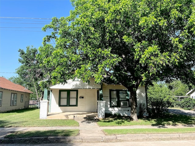 1801 6th St, Brownwood, TX 76801 - view of property hidden behind natural elements featuring covered porch, a front lawn, and cooling unit