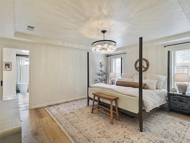 6512 Elkhurst Dr, Plano, TX 75023 - bedroom featuring a textured ceiling, multiple windows, a chandelier, wood finished floors, and ornamental molding