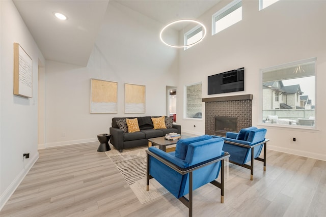 1308 Redbrick Ln, Northlake, TX 76247 - living room with light wood-type flooring, a fireplace, a towering ceiling, baseboards, and recessed lighting