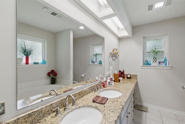 154 Scott Ln, Weatherford, TX 76085 - bathroom with double vanity, tile patterned flooring, a garden tub, baseboards, and toilet