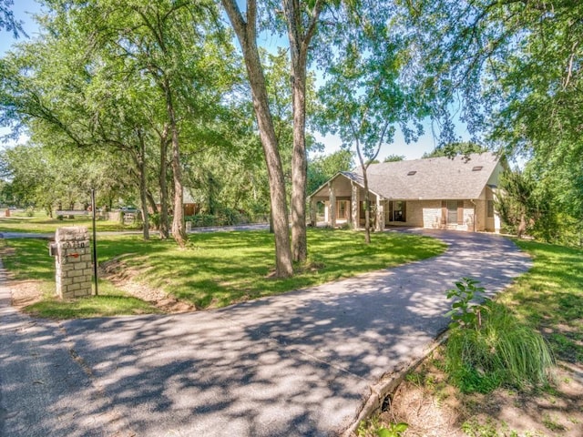 7710 Ravenswood Rd, Granbury, TX 76049 - ranch-style home with a front yard and asphalt driveway