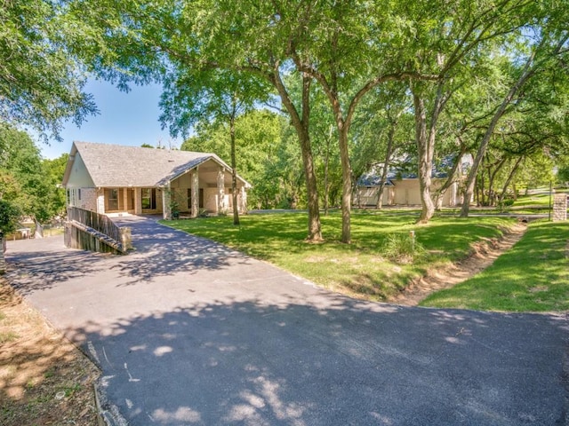 7710 Ravenswood Rd, Granbury, TX 76049 - ranch-style home featuring driveway and a front lawn