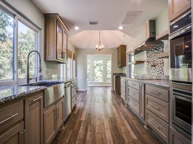 7710 Ravenswood Rd, Granbury, TX 76049 - kitchen with stainless steel dishwasher, a chandelier, a sink, light stone counters, and dark wood-style floors